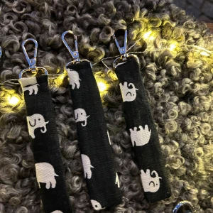 Svart nyckelband med elefantmönster - Vårt uf säljer nyckelband med svenskt tenn motiv. Bandet har en praktisk karbinhake i guld för enkel fastsättning. Perfekt för att hålla koll på nycklarna med stil! Även en perfekt julklapp!