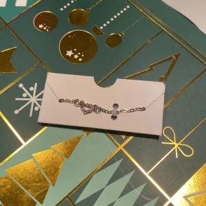 Silverfärgat armband med hjärta - Elegant silverfärgat armband med ett glittrande hjärta. Perfekt för att ge en subtil men stilfull touch till din outfit. Helt oöppnad. Köparen står för frakt!