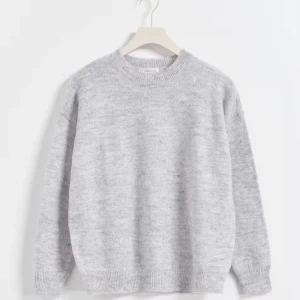 Grå stickad tröja från Gina  - Säljer denna helt oanvända stickade tröja med oversize fit. Den är från ginatricots barnavdelning och är i storlek 170, skulle passa både S och M. Nypris: 250