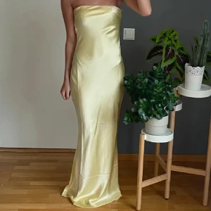 Gul sidenklänning - Säljer denna superduperfina klänning jag köpt här på plick men som tyvärr var för kort på mig som är 177cm. Den är endast testad och har prislappen kvar.☺️Passar perfekt till balen eller andra finare tillfälle💓 Den är från Babyboo. ❗️Hon på bilden är 165 cm ❗️