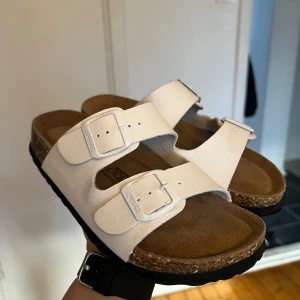 Vita sandaler med spännen - Snygga vita sandaler med två justerbara spännen .