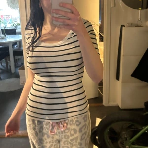 Randig ribbad t-shirt  - Säljer en stilren vit och svart randig ribbad t-shirt från Amisu (newyorker) T-shirten har en rund halsringning och medel korta armar. 