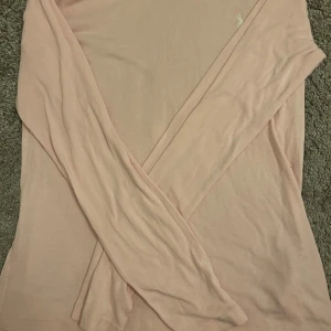 Rosa långärmad tröja från Polo Ralph Lauren - Säljer en mjuk och stilren rosa långärmad tröja från Polo Ralph Lauren. Tröjan har en klassisk design med en liten broderad logotyp på bröstet. Perfekt för en avslappnad och snygg look❤️❤️