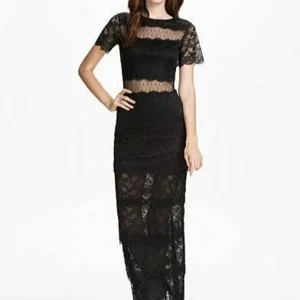 Svart spetsklänning från Dry Lake - Elegant svart spetsklänning från Dry Lake med korta ärmar och transparenta detaljer. Klänningen har en figurnära passform och är perfekt för speciella tillfällen. Den är tillverkad i ett vackert spetsmaterial som ger en sofistikerad look.
