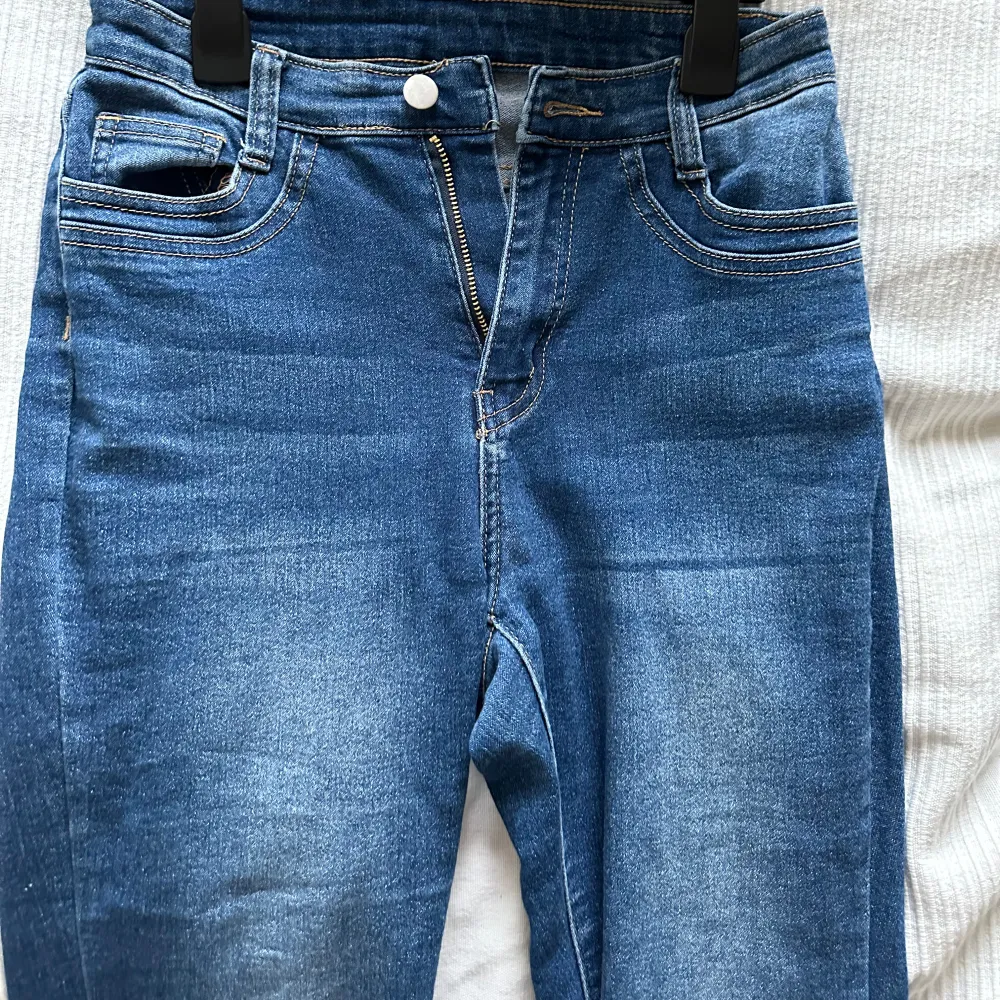 Säljer ett par blå bootcut jeans med dragkedja och knappstängning. Dem är något högre i midjan. De har en snygg tvätt och ser riktigt bekväma ut. Perfekta för vardagsbruk! Passar mig som är 175!. Jeans & Byxor.