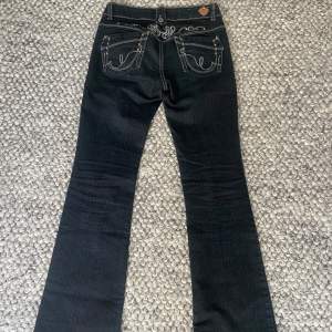 Snygga jeans från Jane Norman. Lågmidjade bootcut, med broderier på rumpan. De är mörkblå men kan se svarta ut ibland. Skulle säga att de är en storlek s/36. De är även väldigt långa, passar mig bra som är 172