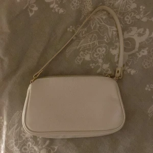 Vit väska - Bra kvalitet, köpte för 2 år sen och knappt använt den. En mindre Axelväska 🤍