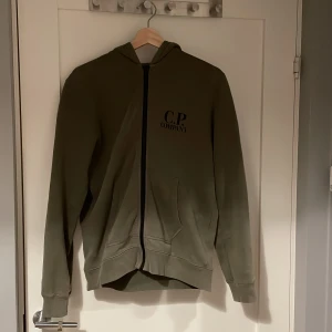 Cp company tröja - En sparsamt använd cp company hoodie. Skulle säga att den passar folk mellan 170-180 beroende på hur man vill att den ska sitta, då den är regular fit.  Stl 14 i barnstolek men är väldigt stor i storlek. Ny pris mellan 3000-3500
