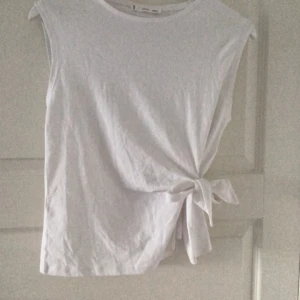 Söt t-shirt  - Super söt t-shirt med knyte på sidan. Köpt från sellpy men aldrig använd av mig. Super bra skick, inga defekter. Är från början från mango💕