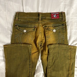 Gula jeans från True Religion - true religion jeans, köpte dem i usa nu i sommras men dem passar inte längre. midja rakt över: 37cm och innerben: 79cm. kom provat för fler frågor