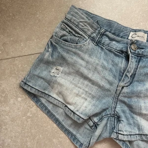 STOCKHOLMSTIL JEANS SHORTS MED HÅL - Säljer mina såå snygga lågmidjade jeans shorts. De är vintage i storlek 164 vilket motsvarar typ XS/S. En ”washed” blå färg med snygga bakfickor. Assnygga hål detaljer. Finns inte att köpa längre! Säljs billigt nu när sommarn är slut så pass på🙃 