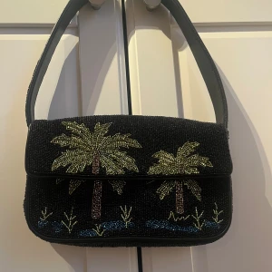 Staud Väska med pärlor - Väska gjord av pärlor med palmer på, ifrån märket STAUD. Nypris ca 3500kr. Aldrig använd men utan etikett. Dustbag medföljer. Pris kan diskuteras!!
