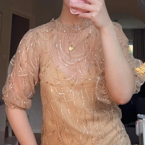 Festklänning - Festklänning med paljetter i guld brons färg. 