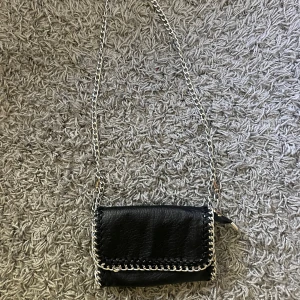 Tiamoväska - Jag säljer en svart tiamo väska i storlek small då den inte används så mycket! Väldigt bra skick!💕skriv om ni vill ha fler bilder!