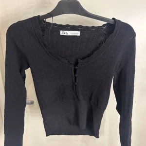 Svart stickad tröja från Zara - Säljer denna svart finstickad tröja från Zara. v-ringad med knappar framtill, nästan aldrig använd i nyskick💕