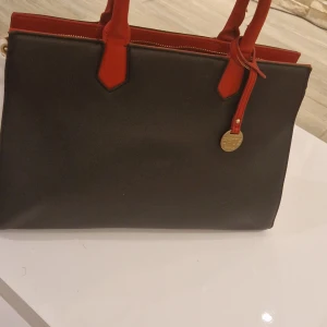 Cruz handväska - Jättefin väska som är knappt använd. Har en knappt synlig repa på framsidan men det är inget som stör utseendet på den. Hör gärna av dig vid fler funderinga.