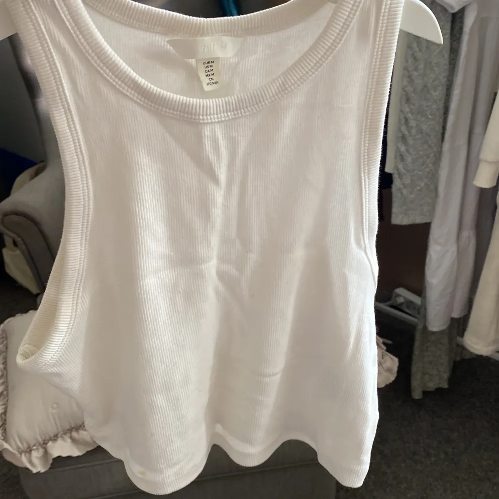 Säljer en vit ribbad linnetopp från H&M. Den är ärmlös och perfekt för sommaren. Toppen är i storlek M och är gjord av ett mjukt och bekvämt material. Perfekt för en avslappnad och stilren look! köparen betalar för frakt . Yläosat.