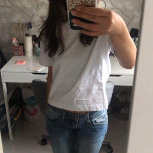 Vit croppad t-shirt - Säljer en vit croppad bomullst-shirt i storlek XS från ginatricot. Den är enkel, stilren och bekväm, perfekt till vardagen! Du kan även styla den med ett spetslinne eller ett vanligt linne (bild 3, 4)🌟