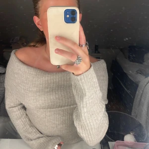 Grå off-shoulder tröja från H&M - Säljer en superfin grå beige off-shoulder tröja från H&M. Den är stickad och har ett ribbat mönster❤️en fin höst färg och jag säljer för den kommer inte till användning, fint skick! tveka inte att skriva om det är nått🥰pris går att diskuteras 
