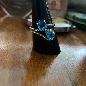 Vacker silverring  - Turkosa stenar med vita kristaller på denna silverpläterade nya ring i storlek 17. Okänt märke. Söt påse medföljer.