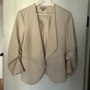 Beige kavaj - Säljer en beige kavaj från H&M då den är liten för mig , använd ett fåtal gånger  Kan skicka fler bilder vid intresse!  Kan vara lite noppad 