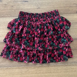 Lindex Kjol - Säljer denna söta blommiga kjolen från Lindex. Kjolen är storlek 146-152 vilket motsvarar 10-12 år men den är väldigt stretchig så den passar 10-14💓  Skriv för fler bilder!💗💗