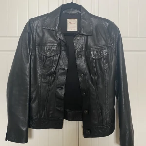 Skinnjacka  - Svart skinnjacka från Replay med knappar. Den är använd fåtal gånger, bra skick! Säljes pga att den inte används 