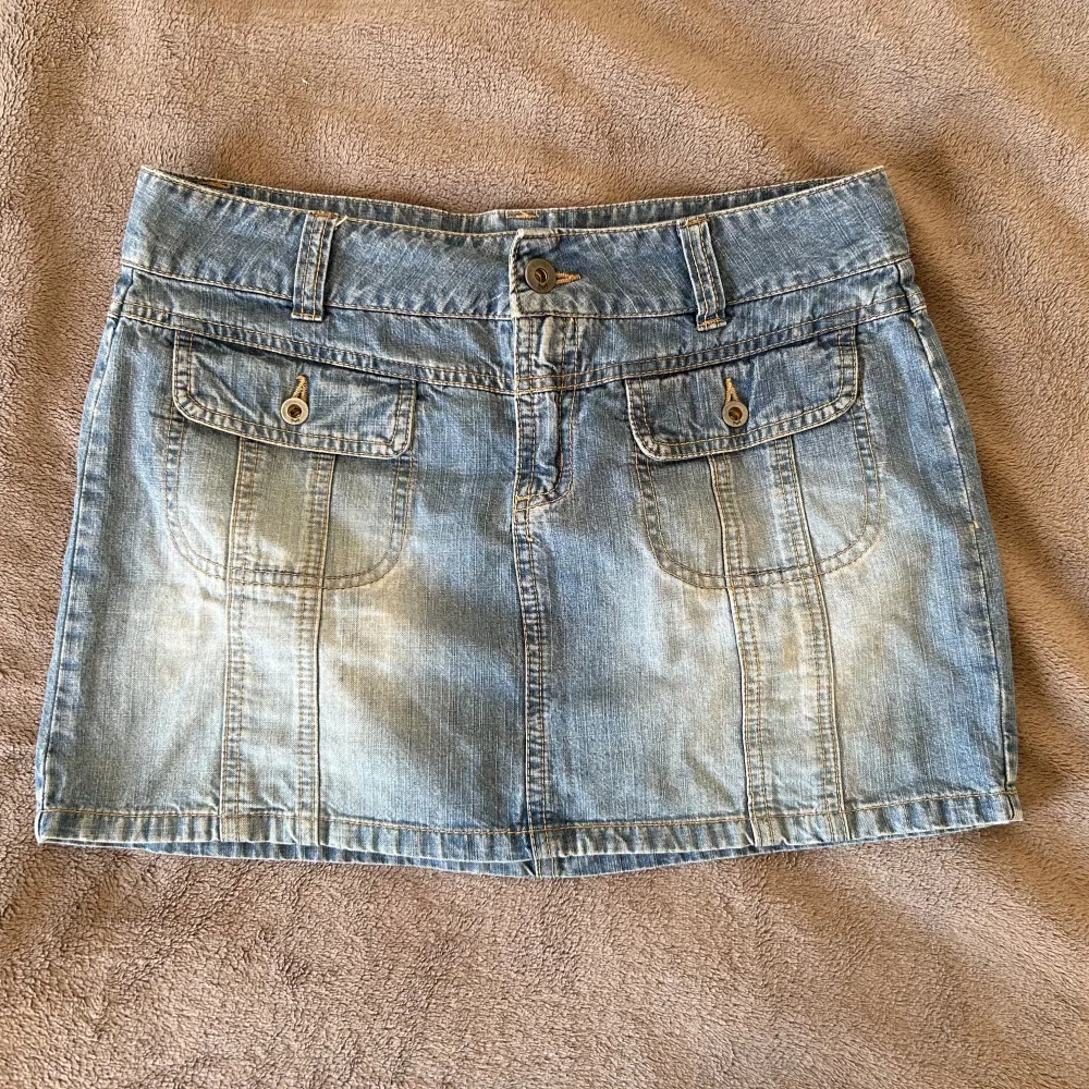 Säljer en snygg jeanskjol från Vero Moda. Den är i en klassisk ljusblå denimfärg och har två fickor framtill med knappar. Kjolen är kort och perfekt nu för hösten! Står ingen storlek men skulle säga S/M❤️ Skriv om du undrar något! Fint skick. Kjolar.