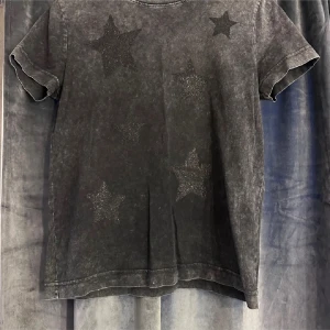 Svart t-shirt med stjärnor från Next Petite - Säljer en svart t-shirt från Next Petite med glittriga stjärnor på framsidan. T-shirten är i bra skick och har en normal passform. Perfekt för en avslappnad look eller en utekväll. 🖤