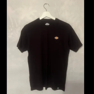 Svart t-shirt från Dickies - Säljer en svart t-shirt från Dickies i storlek XS. Den är i bra skick och har en liten logga på bröstet. Perfekt för vardagsbruk eller som en del av en avslappnad outfit. Passar både till jeans och shorts!