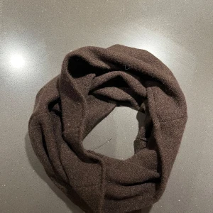 Brun halsduk i 100% kashmir - Säljer en mjuk och stilren brun halsduk i kashmir. Perfekt för att hålla värmen under kyliga dagar. Tillverkad av UF företaget Loui, men vill sälja då jag hellre vill behålla en annan färg från samma företag. Helt ny och oanvänd ! 