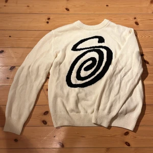 Vit stickad tröja från stussy  - Säljer en stilren vit stickad tröja från stüssy🤩 Tröjan har långa ärmar och ribbade muddar vid ärmslut och nederkant⚜️Perfekt för kyligare dagar! Den är i toppskick och är i princip oanvänd💴Den har en knappt märkbar fläck på baksidan som är så liten att man ej ser den🧉Hör av dig vid frågor🙏