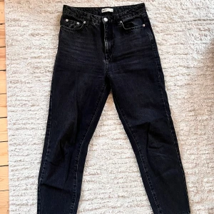 Svarta jeans från Gina Tricot - Snygga svarta jeans från G med hög midja och klassisk femficksdesign. Perfekta för en stilren look. De har en knapp och dragkedja framtill.