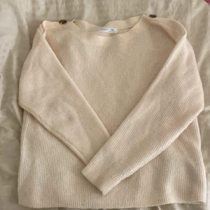 Beige ribbad tröja från Primark - Säljer en superfin beige ribbad tröja från Primark i storlek XS. Den har långa ärmar och snygga knapplister på axlarna som ger en extra touch. Köpte den i somras och har använt den bara 2 gånger, så den är fortfarande i jätte bra skick.