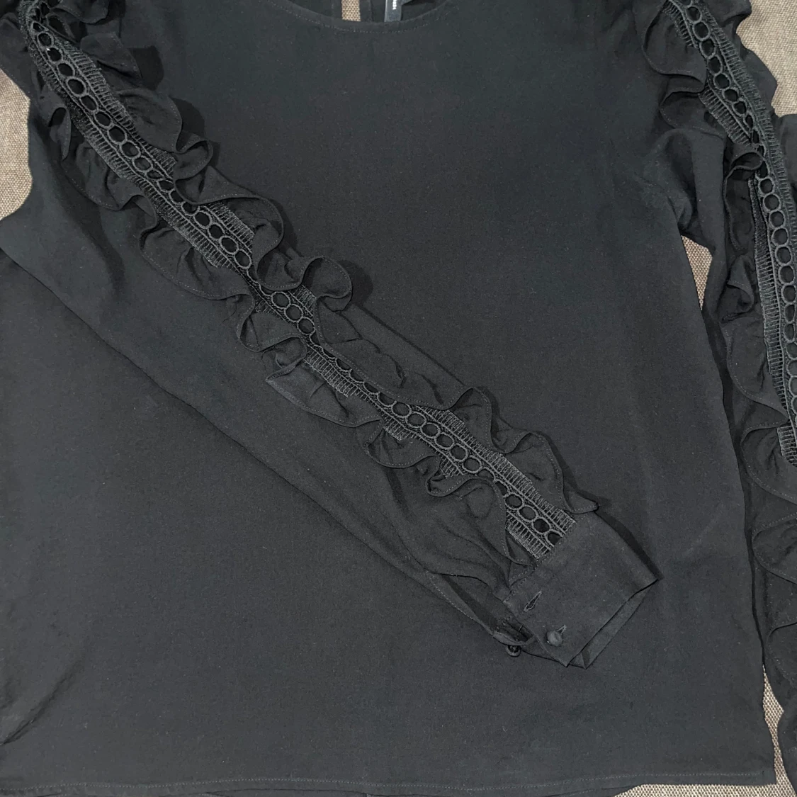 svart blus med volangdetaljer