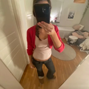 Röd bolerotopp från Stockh LM - Säljer en snygg röd bolerotopp från Stockh LM i storlek M. Den är stickad och perfekt för att lägga till en färgklick till din outfit. Toppen har en kort passform och trekvartsärmar, vilket gör den idealisk för både vardag och fest. Superfin att ha över en enkel topp eller klänning!