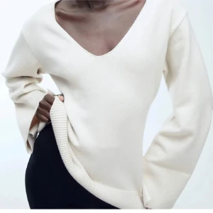 Beige stickad tröja med v-ringning - Säljer en supermysig beige stickad tröja med v-ringning. Den har långa ärmar och ribbade detaljer vid ärmslut och nederkant. Perfekt för kyliga dagar och passar till allt! ✨