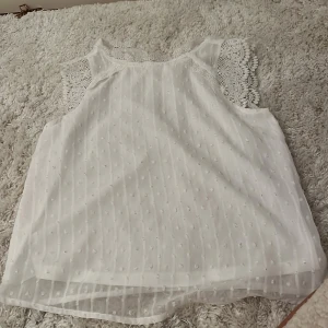 Vit blus med spetsdetaljer - Säljer en söt vit blus med spetsdetaljer vid ärmarna. Den är från only