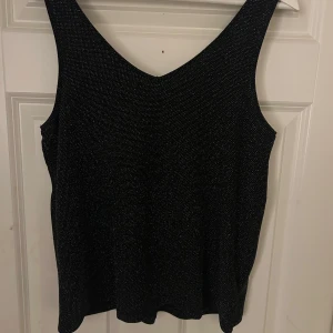 Svart glittrig linnetopp från Esmara - Snygg svart glittrig linnetopp från Esmara i storlek S. Perfekt för festliga tillfällen med sin glittriga yta som fångar ljuset. Toppen är ärmlös och har en bekväm passform. Ett måste för garderoben om du vill sticka ut på nästa fest! Helt oanvänd💕
