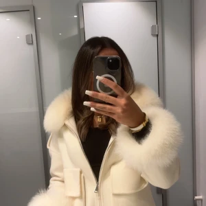 Vit kappa med päls - Säljer min fina kappa med fluffig päls från fur stockholm, nypris 2500 kr. Perfekt för att hålla sig varm och snygg under vintern. Pris går att diskutera💞
