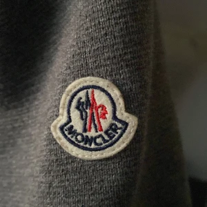 Grå Moncler jacka - Säljer en snygg grå Moncler jacka i mycket bra skick. Jackan har en quiltad design med dragkedja och långa ärmar. Perfekt för höst och vår när du vill hålla stilen och värmen. Passar både till vardags och lite finare tillfällen.