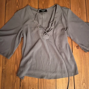 Grå topp vintage - Snygg grå vintage topp från Sisters Point i storlek S. Den har trekvartsärmar och en cool snörning framtill som ger en extra detalj. Perfekt för både vardag och fest! Pris är som alltid diskuterbart!😊 Skriv om du har fler frågor!💕💕