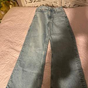 Säljer ett par blå baggy jeans från H&M i storlek 140. De har en justerbar midja och bootcut-ben, vilket ger en avslappnad och trendig look. Perfekta för vardagsbruk och passar bra till både sneakers och kängor.