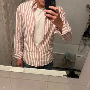 Röd stripad stenströms skjorta - Nu säljer jag min snygga stenstöms skjorta, aldrig använd så 10/10 i skick, absolut inga defekter eller liknande. Köpt för 1400kr, säljer den för 429kr, riktigt skön passform! Det är bara att kontakta mig vid minsta lilla funderingar!