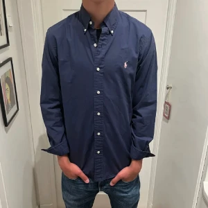 Ralph lauren skjorta  - Hej, säljer en marinblå Ralph lauren skjorta. Den är i bra skick. Skriv bara om ni har några funderingar.