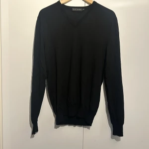 Svart tröja från Ralph Lauren - Säljer en stilren svart tröja från Ralph Lauren i storlek L. Den är gjord av 100% merinoull vilket gör den supermjuk och perfekt för kyligare dagar. Tröjan har en klassisk v-ringning och långa ärmar. Perfekt för både vardag och lite finare tillfällen! Ralph Lauren Black Edition