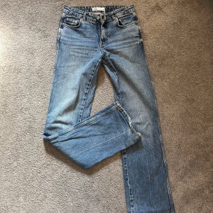 Blåa midrise jeans - Blåa midrise jeans från Zara. Använda och lite rufsiga längst ner men i bra skick! 