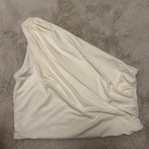 Vit draperad oneshoulder topp från H&M - Väldigt populär topp från H&M som e såså fin! Säljer då den är lite för stor för mig