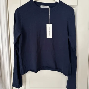 Carin Wester tröja med utsvängda ärmar - Oanvänd mörkblå tröja från Carin Wester med prislappen kvar. Tröjan har utsvängda långa ärmar vid slutet. Köpt för 499 kr.