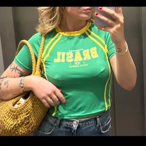 Grön t-shirt  - En grön T-shirt med BRAZIL som text. Köpt begagnad från Sellpy nyskick. Den är sparsamt använd!